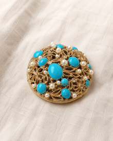 Blue cabochon pearl and rhinestone brooch on linen
