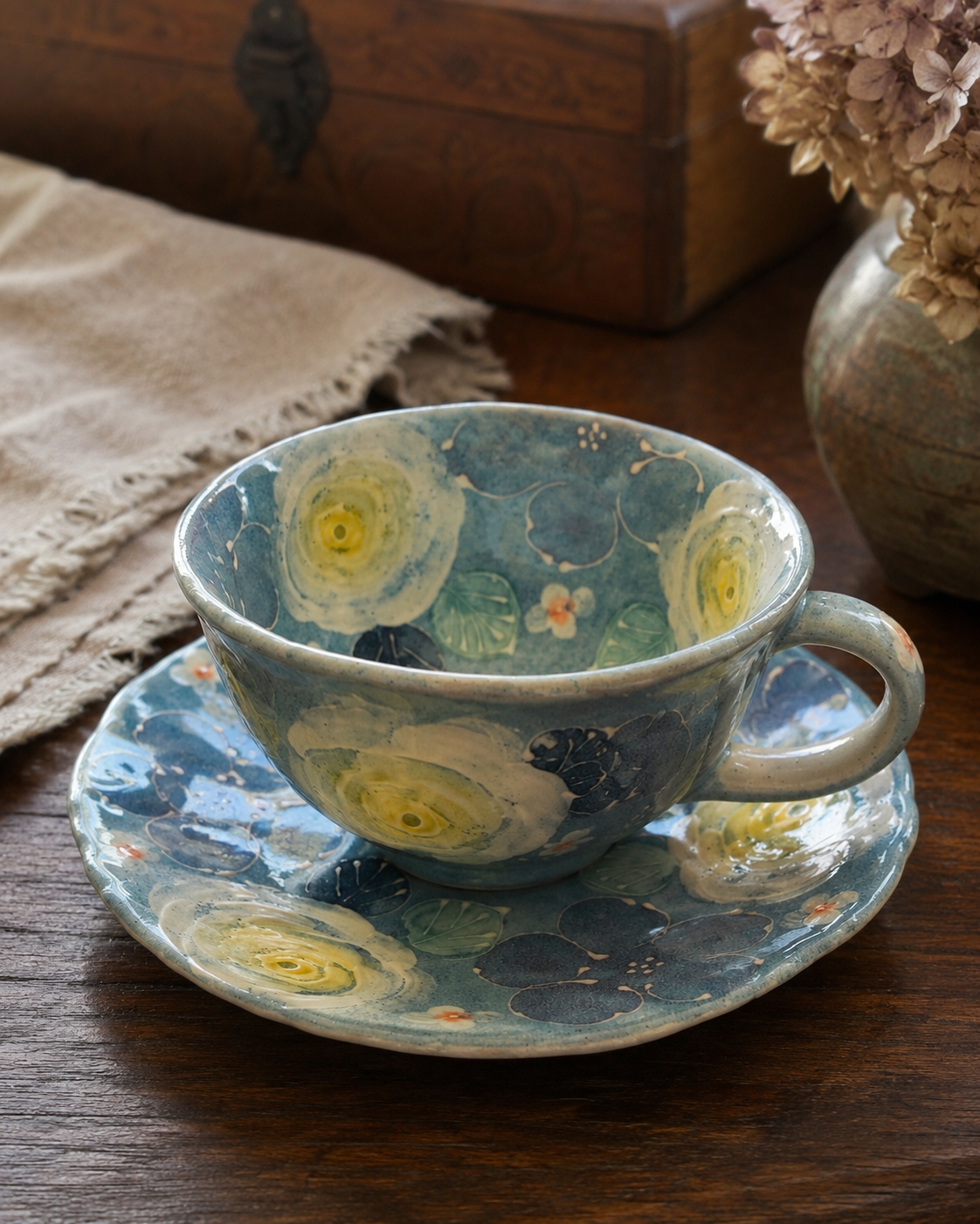 Blue floral ceramic teacup and saucer on a wood table