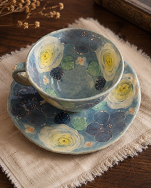 Top view of blue floral teacup and saucer with painted flowers