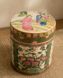 Close view of Chinese famille rose style covered jar with painted lid and floral panel