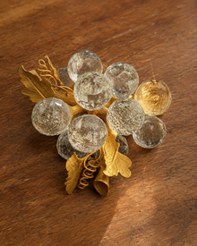 Crystal-look grape cluster brooch on wood table