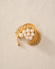 Gold-tone faux pearl leaf brooch on linen