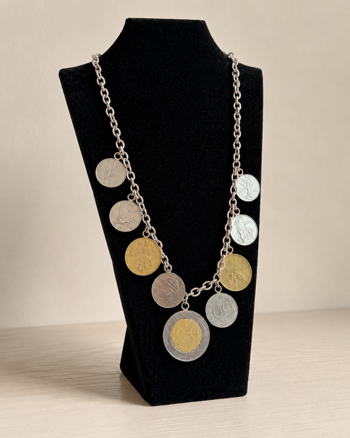 Italian lire-style coin charm necklace displayed on black velvet stand