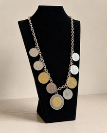 Italian lire-style coin charm necklace displayed on black velvet stand