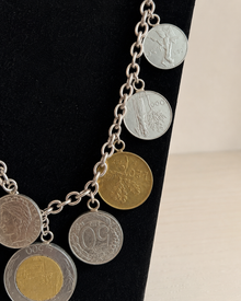 Close view of coin charms on Italian lire-style necklace