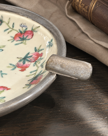 Close view of the silver-tone handle on the porcelain catchall
