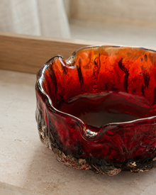 Close view of the red glass ashtray texture and rim
