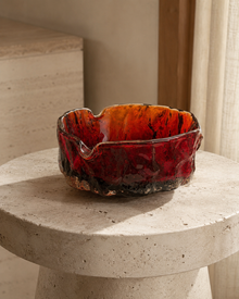 Red glass ashtray displayed on a round stone table