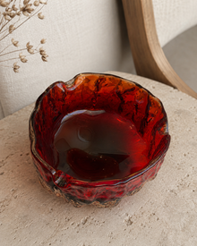 Top view of the red glass ashtray in soft natural light